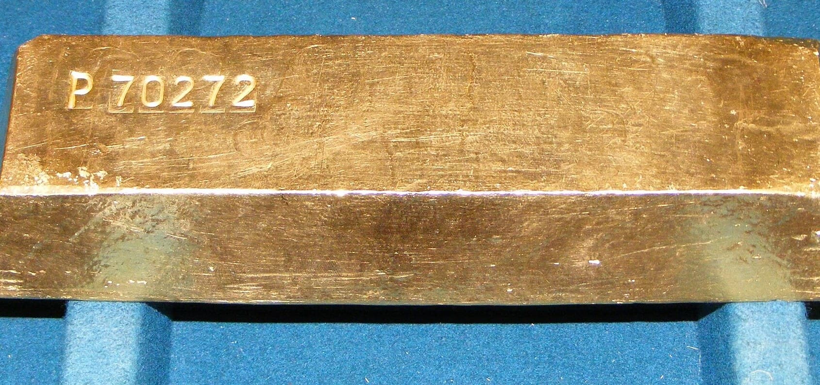 A cast gold bullion bar with its refinery serial number